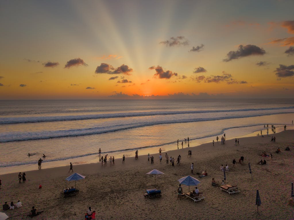 Mesmerizing sunset over a lively Bali beach, perfect vacation backdrop.
